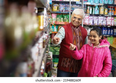 Happy Indian Grand Father With His Grand Daughter Enjoying Purchasing In Grocery Store. Buying Grocery For Home In Supermarket.