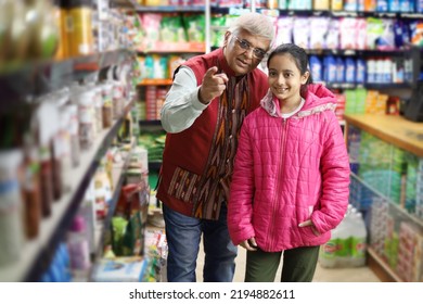 Happy Indian Grand Father With His Grand Daughter Enjoying Purchasing In Grocery Store. Buying Grocery For Home In Supermarket.