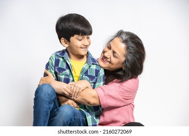 Happy indian grandmother and grandson hug sit on floor look at each other smiling, Isolated on white studio background, Retired grandma with little grand kid bonding, togetherness and family concept. - Powered by Shutterstock