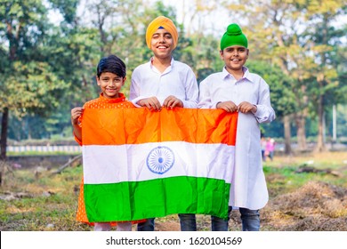 Happy Indian kids holding Indian National flag. Indian Kids celebrating Independence day or Republic day of India.