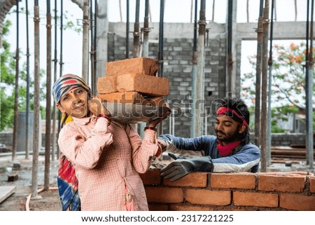 Happy Indian male construction worker constructing brick wall - hard working concept, manual labour Imagine de stoc © 