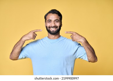 Happy Indian Man Pointing Fingers At Healthy White Teeth Advertising Dentist Services Or Dental Care Product Commercial Promo, Presenting Perfect Smile Standing Isolated On Yellow Background.