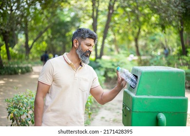 Happy Indian Man Throw Empty Litter In Recycling Bin, Asian Male Drop Plastic Bottle Into Garbage Bin, Pollution Or Waste Management And Save Environment Concept.