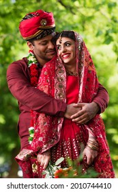 happy indian man in turban hugging bride in red sari - Shutterstock ID 2010744410