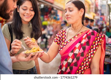 Happy Indian Mother, Daughter And Son Eating Street Food (Bhelpuri) Together In Outdoor Market At Day Time. Shoot Location Sarojini Nagar, Delhi, India.