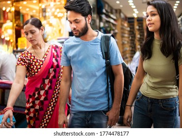 Happy Indian Mother, Daughter And Son Shopping Together From Outdoor Street Market At Day Time. Shoot Location Sarojini Nagar, Delhi, India.
