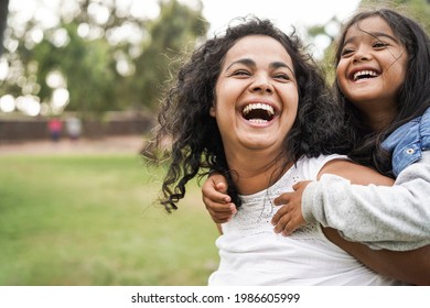 Happy indian mother having fun with her daughter outdoor - Family and love concept - Focus on mum face - Shutterstock ID 1986605999