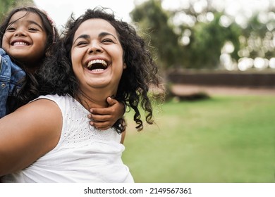 Happy indian mother having fun with her daughter outdoor - Focus on mom face - Powered by Shutterstock