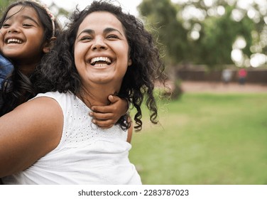 Happy indian mother having fun with her daughter outdoor - Family, mom day and love concept - Focus on mum face - Shutterstock ID 2283787023