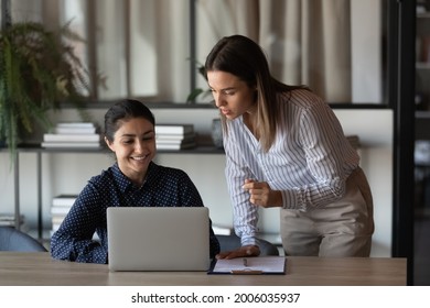 Happy Indian office employee showing job result to boss. Female coworkers discussing project at laptop, talking, laughing. Mentor training intern, supervising work of trainee, explaining task - Shutterstock ID 2006035937