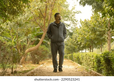 Happy Indian Old man jogging in the park on a Jogging track and trail taking care of his health  - Powered by Shutterstock