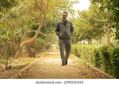 Happy Indian Old man jogging in the park on a Jogging track and trail taking care of his health  - Powered by Shutterstock