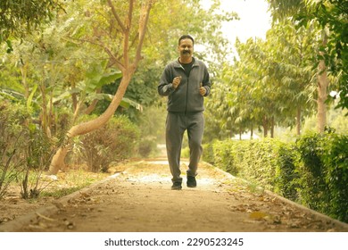 Happy Indian Old man jogging in the park on a Jogging track and trail taking care of his health  - Powered by Shutterstock