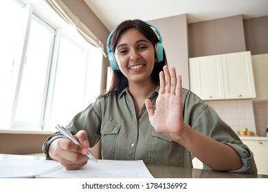 Happy Indian Online Teacher, Student Ot Tutor Wearing Headphones Looking At Webcam Video Conference Calling In Virtual Chat Application Remote Teaching Giving Online Class School Lesson. Headshot.