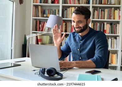 Happy indian professional business man teacher, business coach or hr manager waving hand remote working by video call, having hybrid office online meeting, leading training or webinar elearning class.