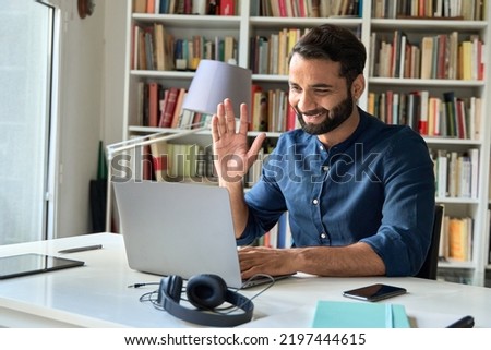 Happy indian professional business man teacher, business coach or hr manager waving hand remote working by video call, having hybrid office online meeting, leading training or webinar elearning class.