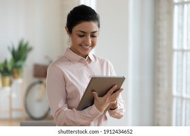 Happy Indian Student Girl Using Tablet For Online Learning. Female Professional Working From Home, Checking Email. Young Woman Chatting On Social Media Or Shopping On Internet. Communication Concept