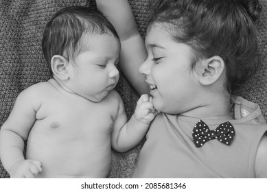 
Happy Indian Toddler Girl Playing With Her Newborn Sister.Toddler Kid Meeting New Sibling. Family With Children At Home. Love, Trust And Tenderness