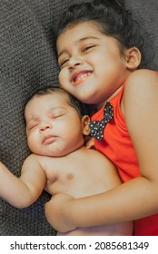 
Happy Indian Toddler Girl Playing With Her Newborn Sister.Toddler Kid Meeting New Sibling. Family With Children At Home. Love, Trust And Tenderness