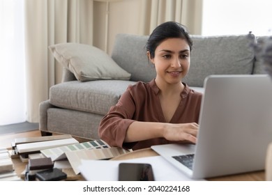 Happy Indian Woman Architect Freelancer Work On Project From Home Office Develop 3d Interior Design Model On Laptop Use Professional App. Young Lady Decorator Choose Panels For Home Improvement Online