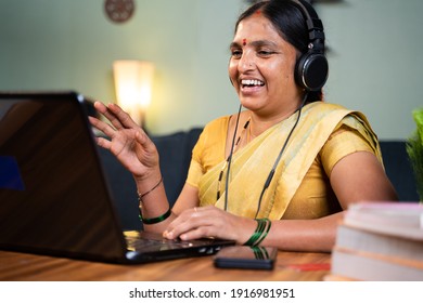 Happy Indian Woman With Headphones Busy Talking In Video Call On Laptop - Concept Of Online Chat, Distance Webinar, Video Conference During Work From Home.