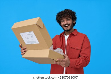 Happy Indian Young Man Holding Open Parcel Box Isolated On Blue Background. Smiling Guy Customer Receiving Product Retail Order Purchase In Postal Shipping Delivery Unpacking Package.