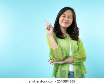 A Happy Indonesian (Asian) Girl Caught An Idea On A Blue Isolated Background