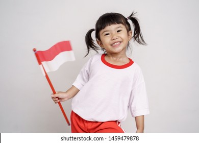 Happy Indonesian Kid With Flag Over White Background