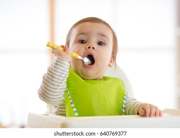 baby holding spoon