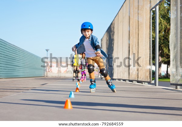 Happy inline skater\
slaloming at skate park
