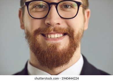 Happy intelligent redhead business man in glasses with ginger beard and mustache and healthy natural straight teeth smiling on gray studio background. Headshot, face closeup shot. Men's style concept - Powered by Shutterstock