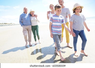 Happy Intergenerational Family Walking On The Beach