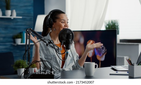 Happy Internet Live Radio Morning Show Host Talking To Audience On Microphone. Joyful Social Media Content Creator Hosting Online Broadcast While Speaking To Public In Modern Living Room Studio.