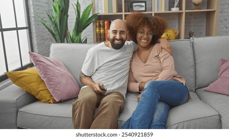 A happy interracial couple embracing on a couch with a remote, enjoying leisure time in a cozy living room. - Powered by Shutterstock