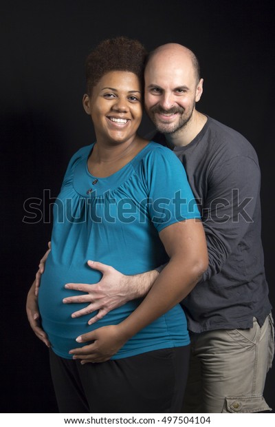 Happy inter-racial couple, pregnant african american wife and caucas photo