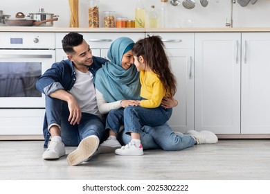 Happy Islamic Parents Bonding With Their Little Daughter In Kitchen, Portrait Of Cheerful Smiling Middle Easter Family Of Three Relaxing On Floor, Enjoying Spending Time Together, Free Space