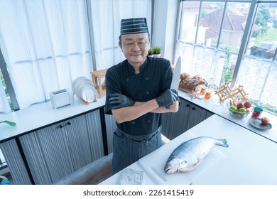 Happy japanese chef presenting a set of sashimi. The Asian man kitchen knife. - Powered by Shutterstock