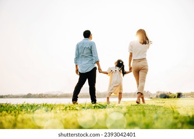 Happy Japanese family walking together in a scenic garden, with a beautiful nature backdrop and the sun shining, enjoying quality time outdoors, Family care, back view - Powered by Shutterstock