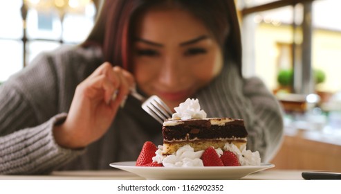 Happy Japanese woman indulges in fancy dessert