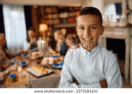 Happy Jewish kid standing with crossed arms while celebrating Hanukkah with his family at home and looking at camera. ストックフォト © 