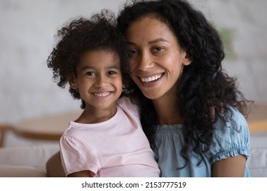 Happy Joyful Black Mom And Adorable Daughter Kid Head Shot Portrait. African Mother Hugging Preschool Child, Looking At Camera With Toothy Smile. Video Call Screen Shot