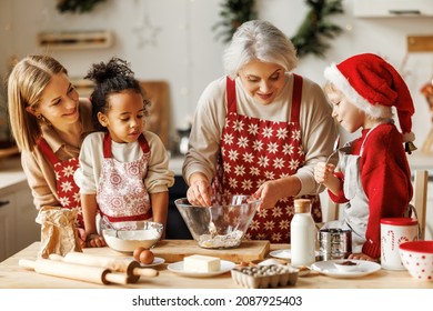 Happy Joyful Multiethnic Family With Kids Cooking Together On Christmas Day In Kitchen. Grandmother, Mother And Multiracial Children Baking Traditional Xmas Meal And Laughing. Winter Holidays At Home