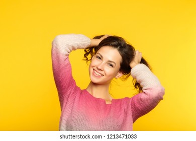 happy joyful smiling girl making pig tails from her hair. relaxed carefree teenage lifestyle and childish behavior. young beautiful brown haired woman portrait on yellow background. - Shutterstock ID 1213471033