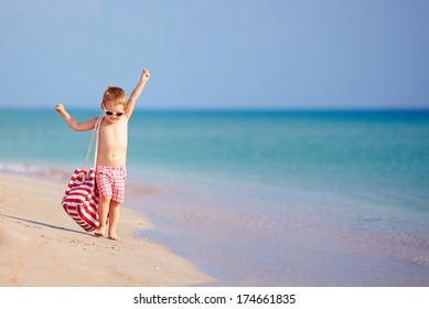 happy kid boy walking the summer beach