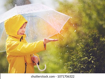 happy kid catching rain drops in spring park - Shutterstock ID 1071706322