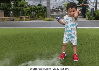 A happy kid embraces the magic of play amidst the enchanting mist at Foggy Bowl, Jewel Changi Airport.
