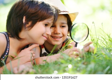 Happy kid exploring nature with magnifying glass