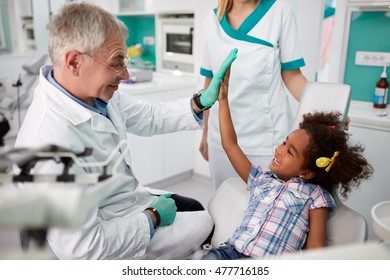 Happy Kid Giving Five To Dentist In Dental Clinic