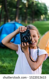 Happy Kid Holding Digital Camera While Taking Photo Near Camps 