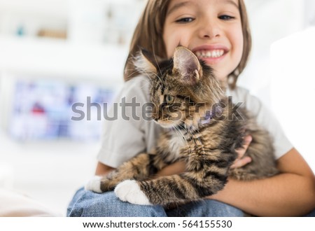 Happy kid at home playing with kitty cat